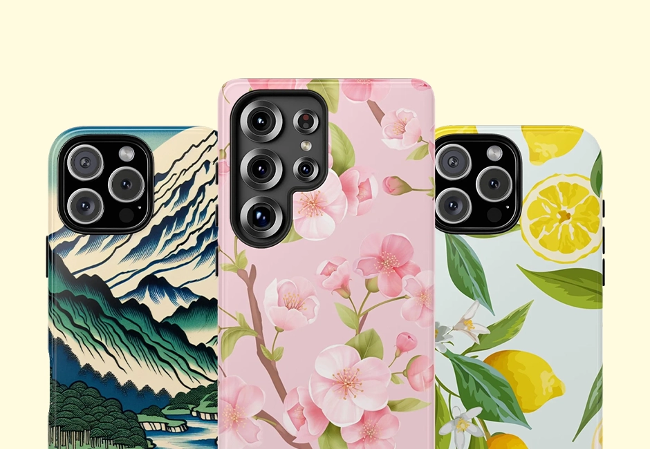 Three iPhones encased in MVB Studio tough cases, featuring a variety of artistic designs: a Japanese wave-inspired print, a pink cherry blossom floral pattern, and a vibrant lemon-themed design, all set against a soft pastel background.